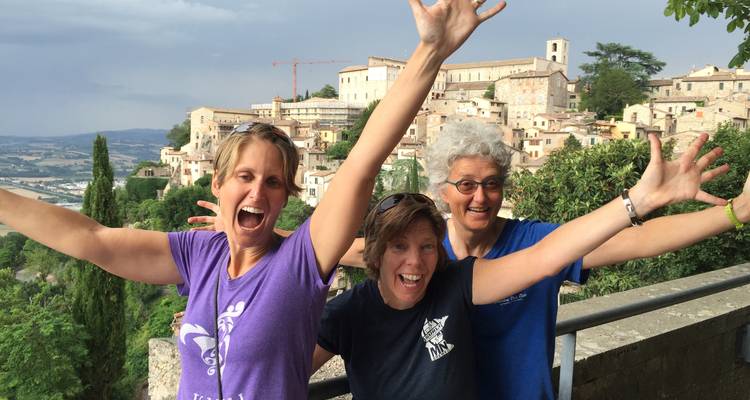 Trois femmes posant avec exubérance dans une ville italienne pittoresque.