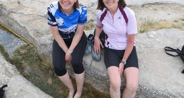 Deux femmes se reposant près d'un ruisseau pendant qu'elles font du vélo.