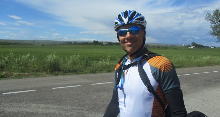 Cycliste masculin posant devant un vaste paysage.