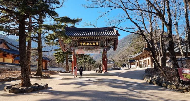 Une porte d'entrée avec un paysage de montagne en arrière-plan dans un complexe de temples.