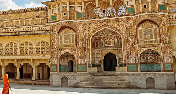 Eine reich verzierte Palastfassade mit einer Person in traditioneller Kleidung.
