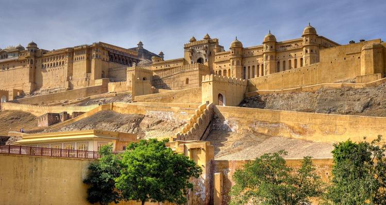 Eine historische Festung an einem Hang unter klarem Himmel.