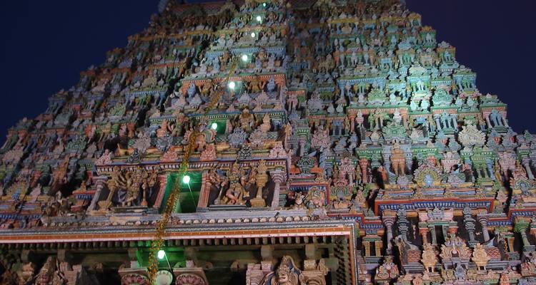 Ingewikkeld gesneden tempeltoren verlicht in de schemering.