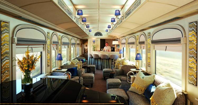 Luxurious train interior with seating area and bar.