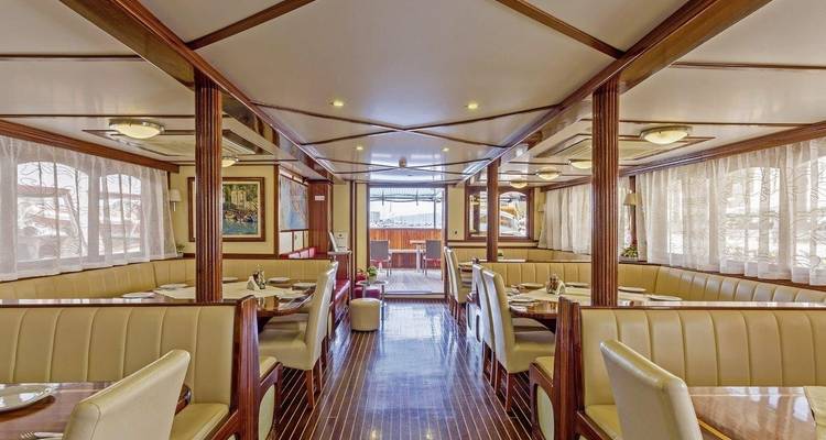 Zone de restauration élégante sur un bateau avec des tables bien agencées.