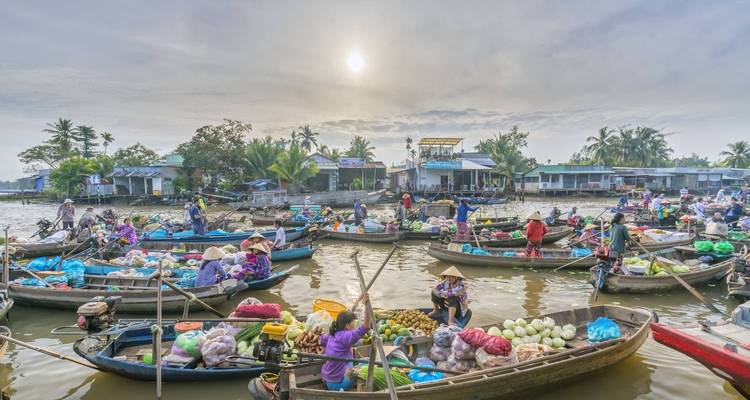 Marché flottant animé avec des bateaux chargés de marchandises dans le delta du Mékong.