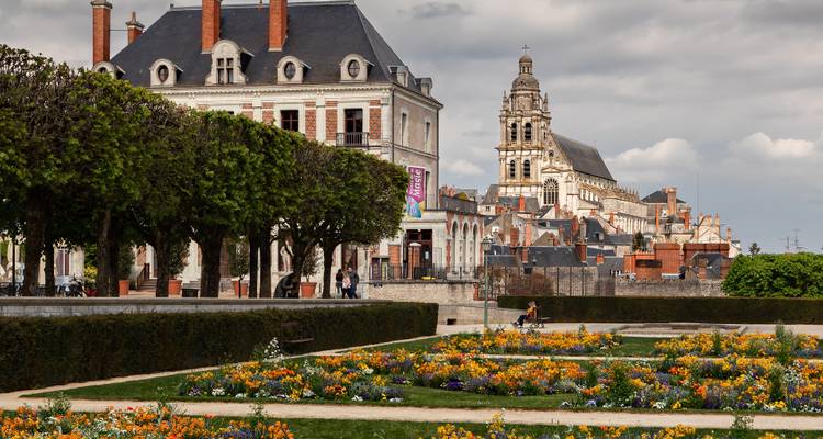 Jardins et bâtiments historiques de Blois avec la tour de la cathédrale en arrière-plan par un après-midi nuageux