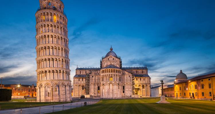 Avondaanzicht van de Scheve Toren en de Kathedraal van Pisa op het Piazza dei Miracoli onder een blauwe schemering