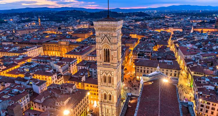 Luchtfoto van Florence tijdens het blauwe uur met Giotto's Campanile uittorenend boven de verlichte daken van de stad