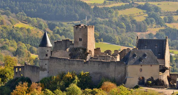 Middeleeuwse stenen kasteelruïnes met ronde toren op een bebost heuveltje in Trentino