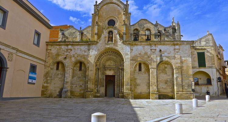 Fachada histórica de edificio de piedra con arcos.