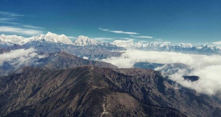 Weitläufiger Bergblick mit schneebedeckten Gipfeln und Wolkendecke.