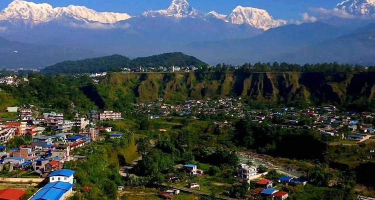 Vista amplia del pueblo de Pokhara con la cordillera nevada del Annapurna dominando el horizonte bajo cielos azules