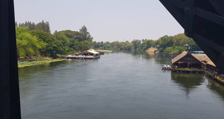 Ein ruhiger Fluss mit Booten und üppig grüner Umgebung.