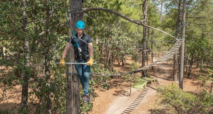Homme en équilibre sur une corde dans un parc d'aventure