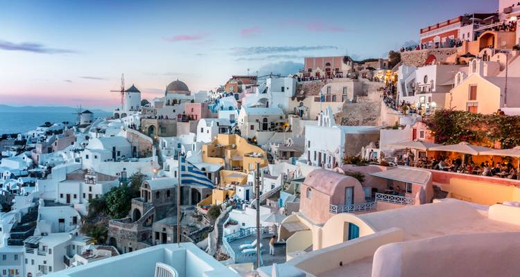 Weiß getünchte Gebäude mit Meerblick bei Sonnenuntergang auf einer griechischen Insel.