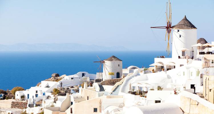 Casas encaladas icónicas y molinos de viento tradicionales con vistas al profundo azul del Egeo en Santorini
