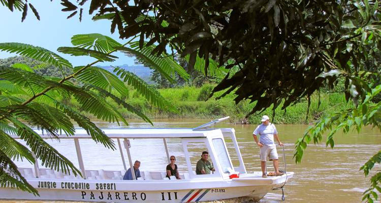 Des touristes lors d'une excursion en bateau-safari sur une rivière tropicale.
