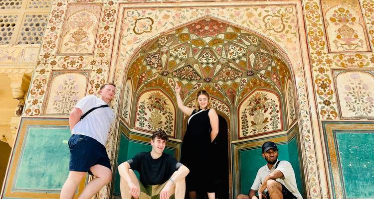 Groupe posant sous une arche décorée dans un bâtiment historique.