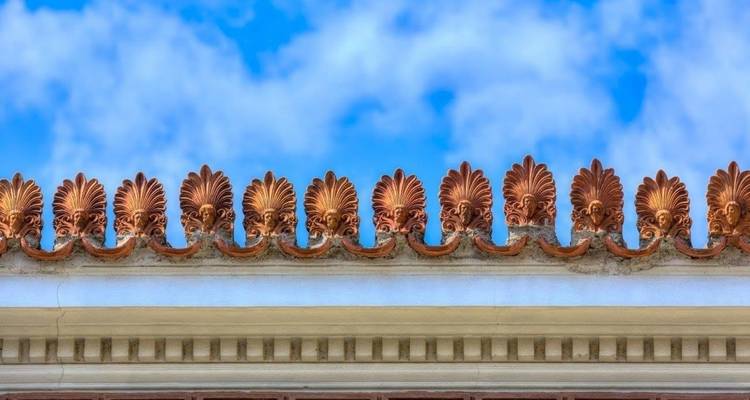 Sierlijke dakdecoratie tegen een blauwe lucht.