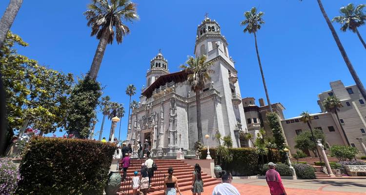 Historic building with ornate facade and tourists walking by.