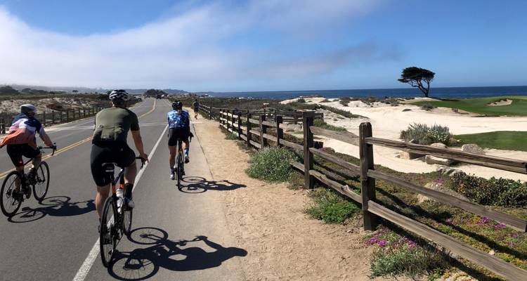 Cyclists riding along a coastal path with scenic ocean views.