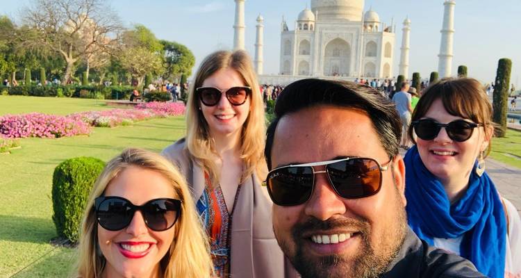 Groupe de touristes prenant un selfie devant le Taj Mahal.