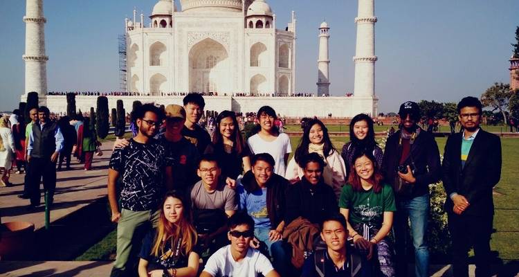 Groupe de touristes posant devant le Taj Mahal.