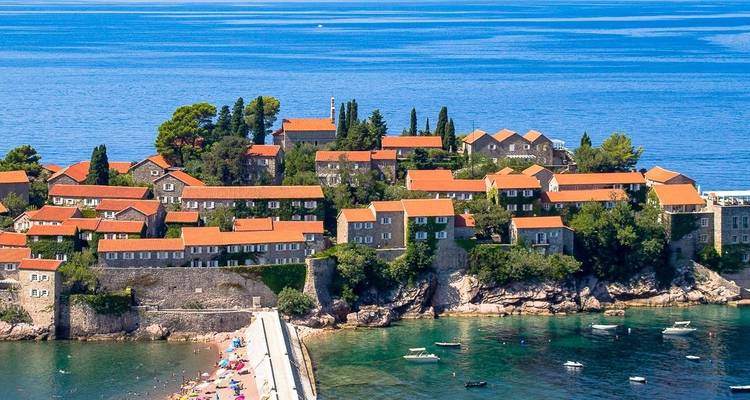 A picturesque seaside town with red roof tiles by the sea.
