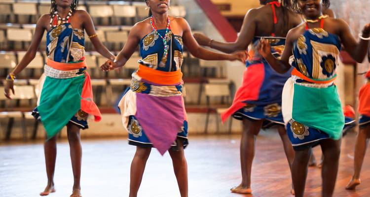 Close-up of dancers in traditional attire indoors.