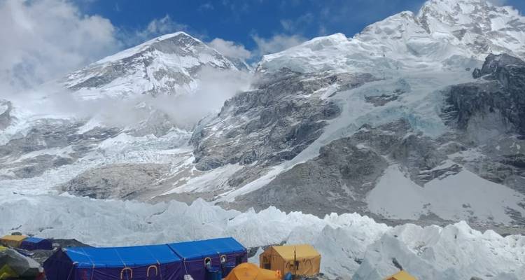 Des tentes colorées au camp de base de l'Everest avec des montagnes enneigées.
