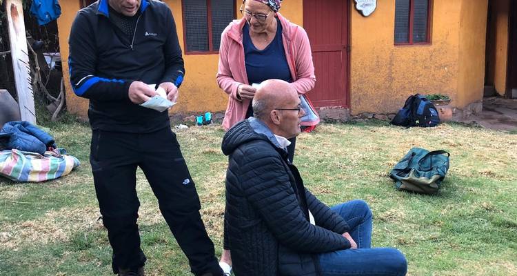 Trois personnes interagissant à l'extérieur avec des sacs à leurs pieds.