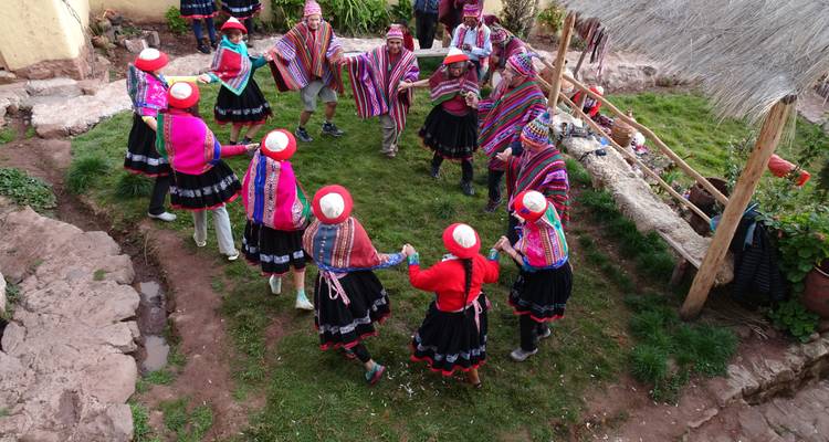 Des personnes en tenue traditionnelle dansant en cercle.