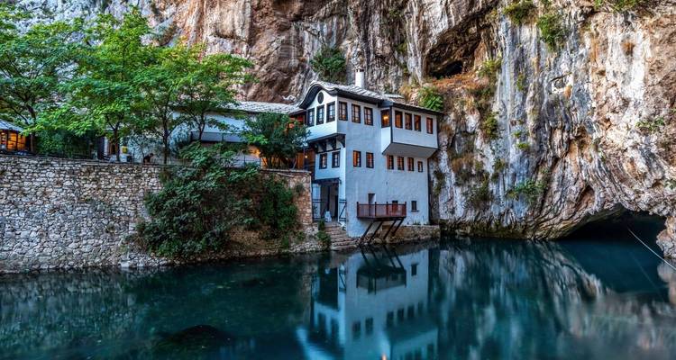 Een huis gebouwd in de rotswand aan het water.