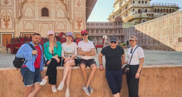 Groupe de touristes assis dans une cour historique.