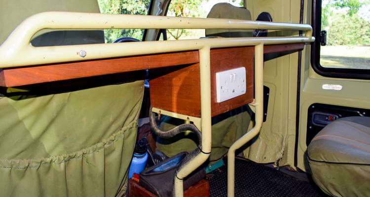 Interieur van een safarivoertuig met utiliteitstafel en stopcontact.