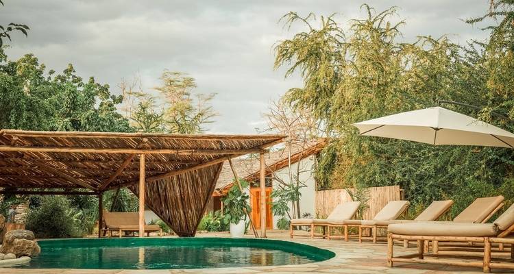 Buitenzwembadgebied met comfortabele ligstoelen en schaduw