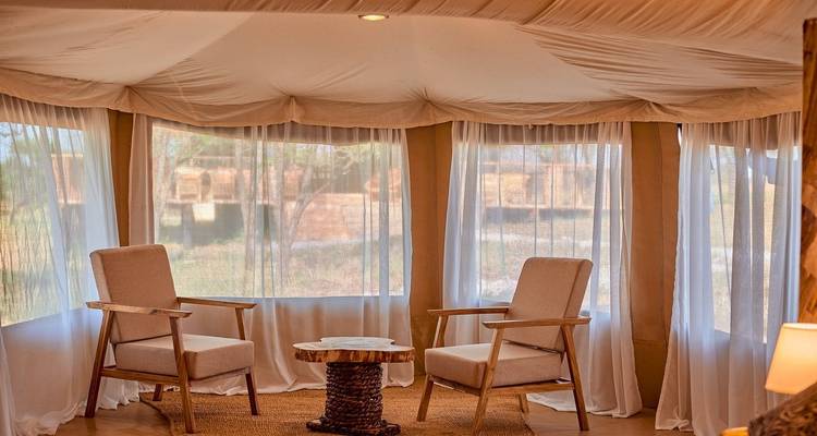 Zithoek met twee stoelen en een kleine tafel in een tent