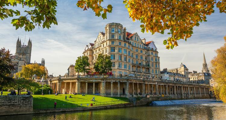 Historical building with columns by a river.