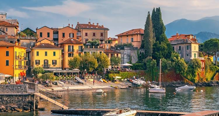 Picturesque houses along a waterfront with people dining.