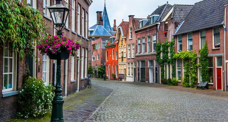 Kleurrijk straatbeeld met traditionele huizen en een kinderkopjesweg.