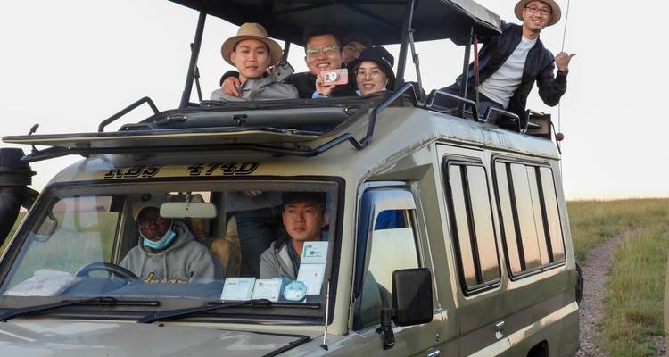 Gruppe von Menschen in einem Safari-Fahrzeug, die eine Wildtier-Tour genießen.