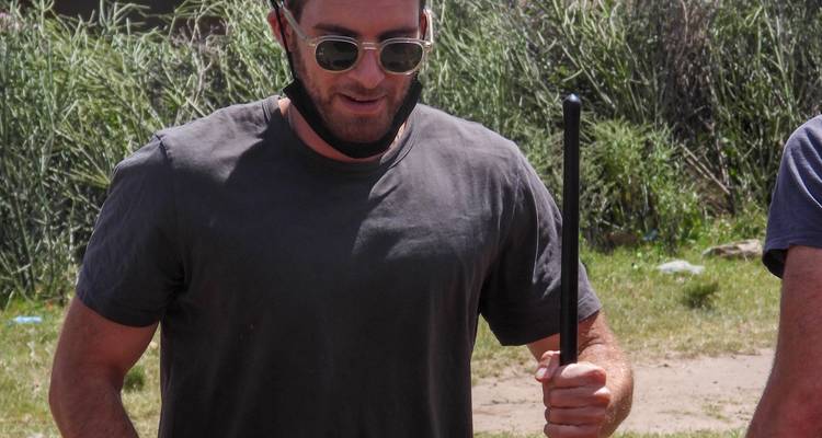 Mann mit Sonnenbrille und Stock im Freien.