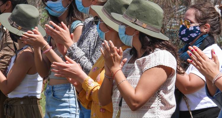 Gruppe von Menschen mit Hüten und Masken, die klatschen.