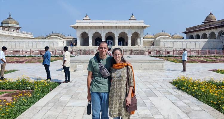 Couple standing in the marble courtyard of Agra Fort surrounded by Mughal pavilions.