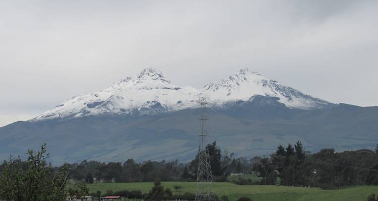 Montagnes enneigées sous un ciel nuageux.