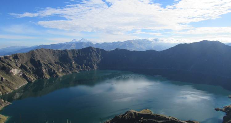 Lac de cratère avec montagnes et nuages.