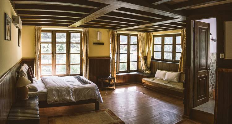 Gezellige kamer met grote ramen en houten accenten.