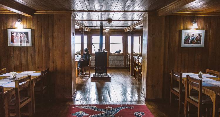 Rustieke eethoek met houten interieur en ingelijste foto's.