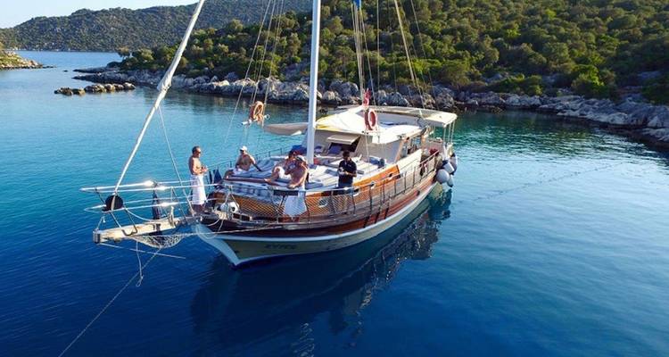 A group of people on a yacht in a scenic bay.